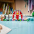 LEGO Disney Toy Story horse ranch display features red, teal and lavender plastic structures, fenced paddocks and animal figures arranged as a farm scene on a tabletop in a bedroom setting.