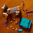 LEGO Disney Pixar Toy Story building set shows brown and tan plastic Slinky Dog sections, colorful bookend pieces, loose bricks and Woody figures arranged on a wooden tabletop during assembly.