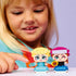 LEGO Disney Frozen Mini Anna and Elsa play experience featuring a child smiling while holding the completed mini figures, highlighting the colorful outfits, expressive faces, and interactive accessories indoors.