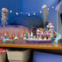 LEGO Disney Princess Ariel's Royal Wedding Boat in white, lavender, pink, and teal plastic is displayed with Ariel, Eric, sea friends, and King Triton's chariot on a table.