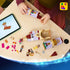 LEGO Disney Princess castle set in lavender, tan, red, and gold plastic is built by a child at a table using digital instructions, with figures, accessories, and tower sections.