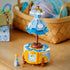 LEGO Disney Princess Cinderella dress display in light blue, white and gold plastic with mannequin-style gown above a decorative cabinet, beside Cinderella and mouse figures on a wooden tabletop.