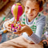LEGO Disney Princess balloon in bright pink, gold and purple plastic is held by a smiling child, with a Rapunzel mini-doll seated inside the round basket at home.
