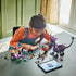 LEGO Disney Princess Maleficent's Dragon Form set in colorful plastic as a child assembles the castle, dragon and character figures beside a tablet showing digital building instructions.