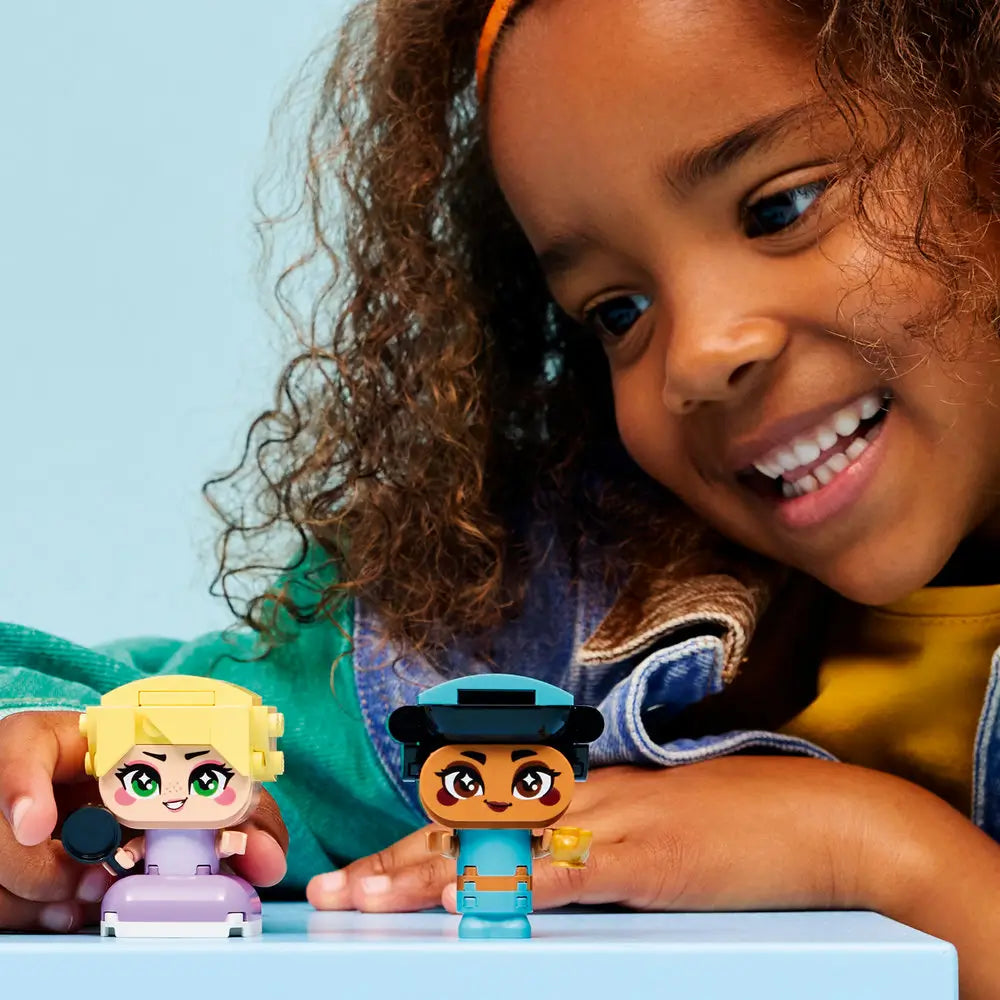 LEGO Disney Princess building activity image showing a child holding teal mini figure while purple figure rests nearby, highlighting smooth plastic textures and guided digital building steps.