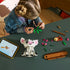 LEGO Disney Moana Pua set in white, gray, pink, green, and brown plastic is assembled by a child at a dark table beside tablet instructions, loose pieces, Heihei, and a brown base.