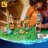 LEGO Disney Princess Rapunzel's Castle pieces in tan, pink, turquoise, and gold plastic cover a green table as a child builds a tower beside digital instructions on a tablet.