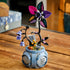 LEGO Disney Sally flowerpot display shows a blue rounded cauldron with engraved label, black curved stems, purple blossoms, and multicolor patterned petals forming a gothic flower, placed on a wooden table in a home interior.