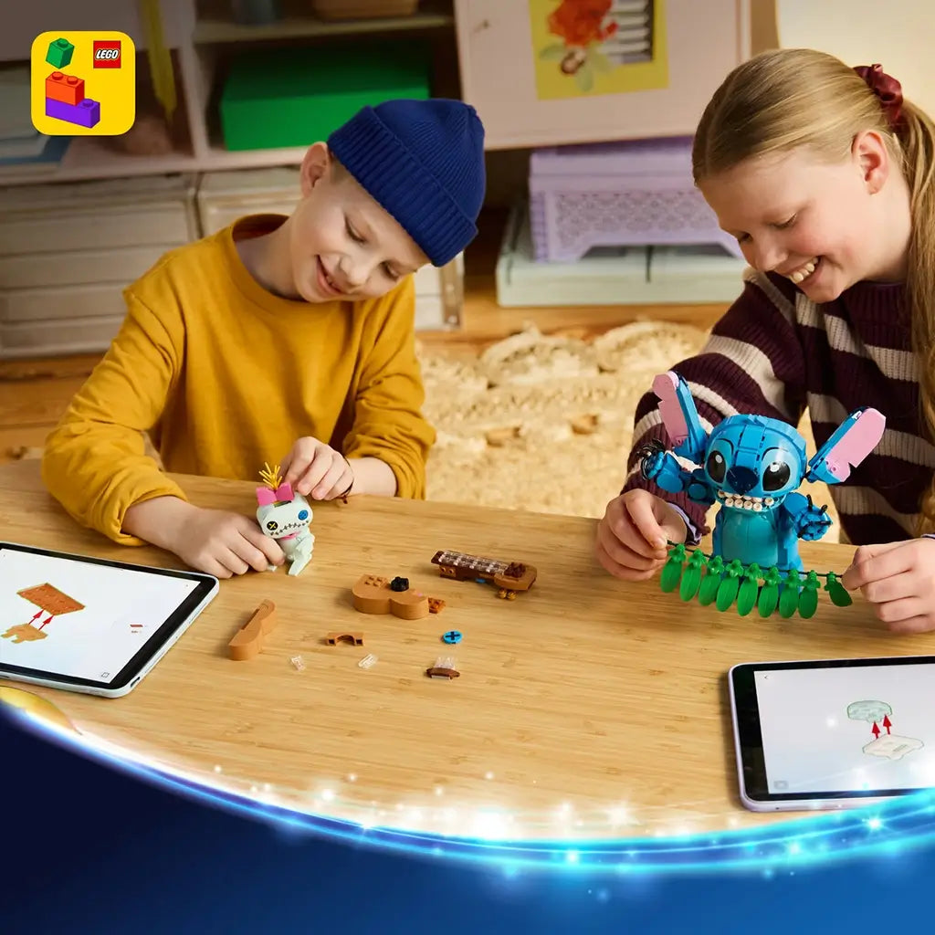 LEGO Disney Stitch and Scrump building set in blue, pink, green, and tan plastic is assembled by two children at a wooden table using digital instructions on tablets.