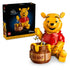 LEGO Disney Winnie the Pooh display set in yellow and red plastic, completed bear figure with honey pot and bees, product shown with retail box on a clean studio background.