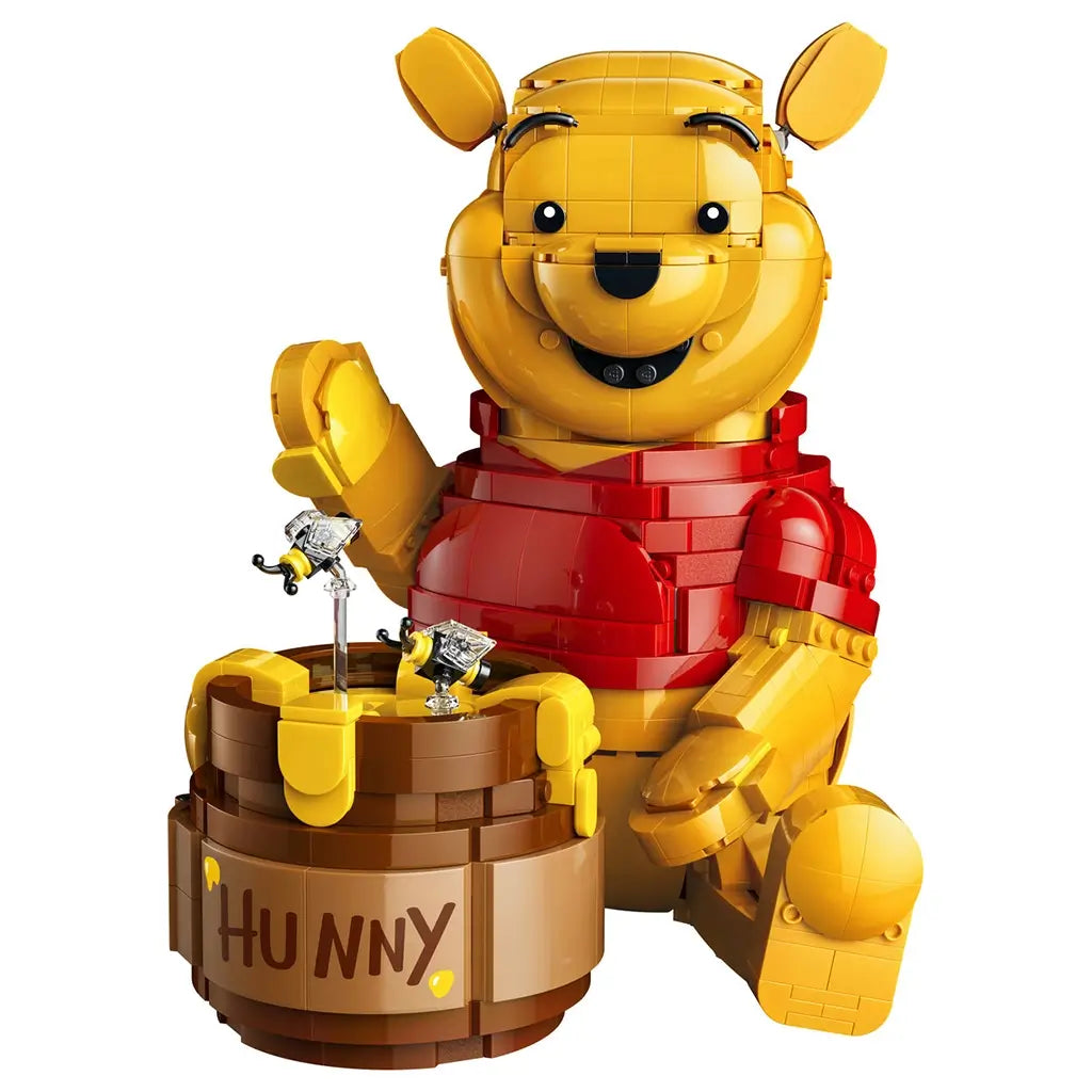 LEGO Disney Winnie the Pooh figure in bright yellow and red plastic, rounded character holding honey pot with dripping detail and bees, collectible display model on a clean white background.