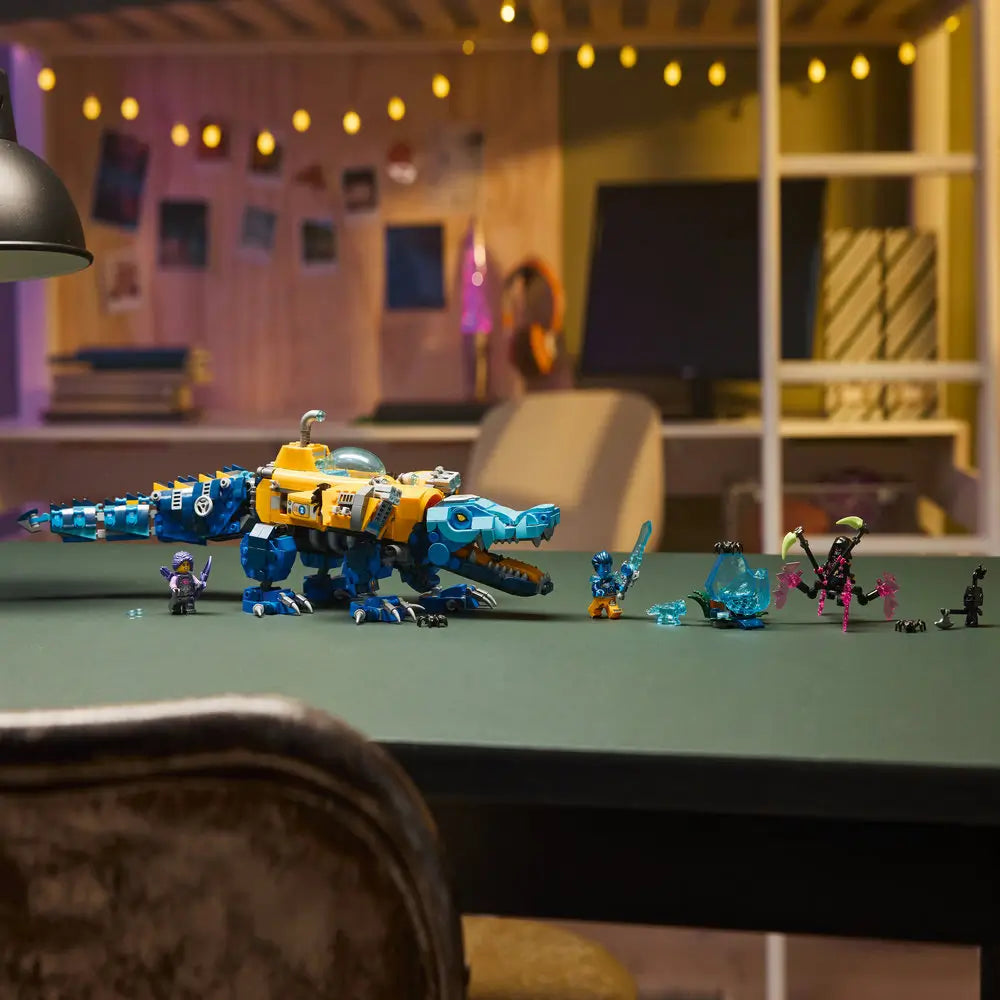 LEGO DREAMZzz Crocodile Submarine is fully built and displayed on a table with blue and yellow mechanical body, articulated tail and jaws, minifigures, and accessories arranged for scale and play.