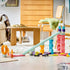 LEGO DUPLO Creative Ramps display features mint, pink, blue and white plastic towers, a long sloped track, orange loop, two race cars and loose ramps in a living room.