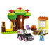 LEGO DUPLO Bluey Pizza Girls set 10469 features colorful plastic tree, swing, house, campfire, pizza and black car builds with Bluey and Muffin figures on white.