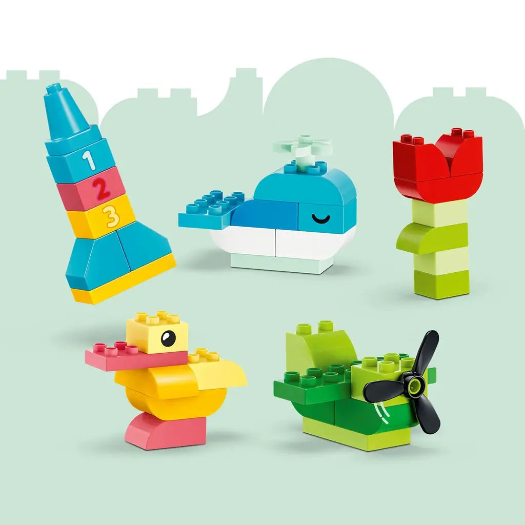 LEGO DUPLO Colorful Creative Box models use bright plastic bricks to form a numbered tower, blue whale, red flower, yellow duck and green propeller boat on a mint backdrop.