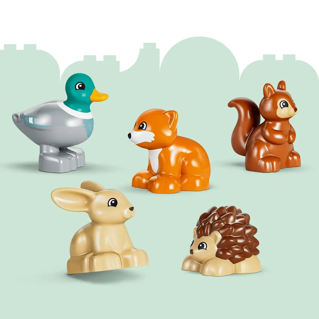 LEGO DUPLO wild animal figures include a gray and teal duck, orange fox, brown squirrel, tan rabbit and brown hedgehog, molded in smooth plastic on a pale green background.