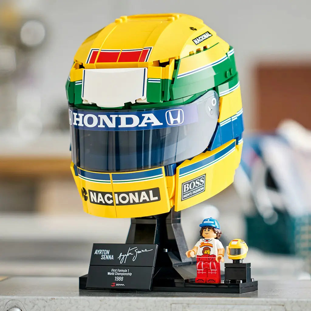 LEGO Ayrton Senna Helmet set 43024 features a yellow, green and blue brick-built racing helmet with Honda and Nacional logos, black display stand, plaque and minifigure.