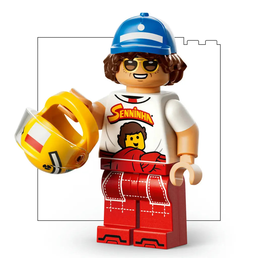 LEGO Ayrton Senna minifigure wears a blue cap, white Seninha shirt and red racing pants while holding a yellow helmet with clear visor against a clean white background.