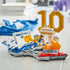 LEGO Kylian Mbappé soccer collectible features blue, white, gold and red plastic brick construction shaped as a football celebration scene with number 10, goal frame and landmark details, displayed on a tabletop.