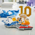 LEGO Kylian Mbappé soccer display features blue, white, gold and red plastic brick construction shaped as a football highlights scene with a kicking minifigure, goal frame and number 10 centerpiece on a table.