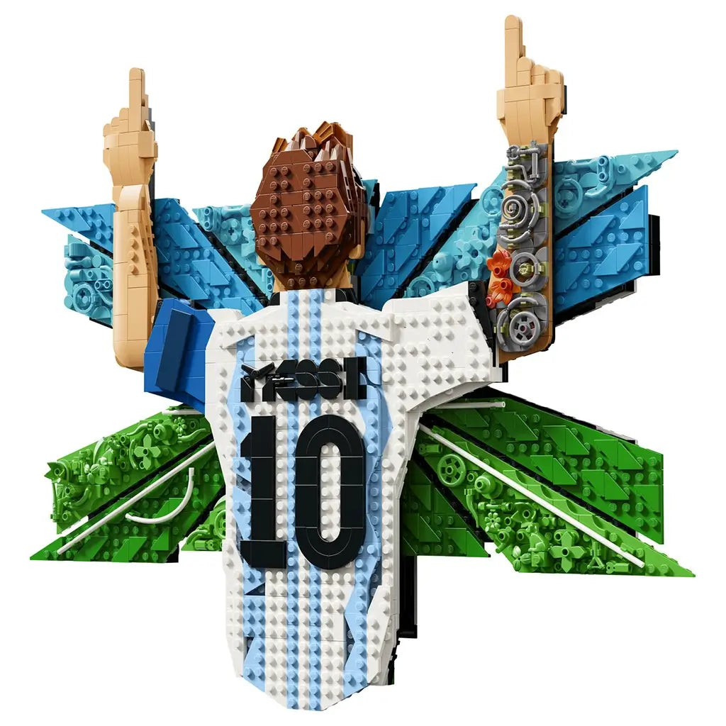 LEGO Lionel Messi wall art display features white, sky-blue and green plastic brick elements forming Messi’s number 10 Argentina jersey with raised arms, mounted over a textured soccer-themed geometric background.