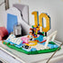 LEGO Lionel Messi soccer display built from blue, green, white and gold plastic bricks, featuring a number 10 landmark, football action effect, goal frame and collectible nameplate on a plain backdrop.