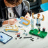LEGO Lionel Messi soccer building set features light blue, white, black, gold and green plastic brick components being assembled beside digital instructions, with figure, backdrop and ball elements.