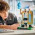 LEGO Lionel Messi soccer collectible features light blue, white, black, gold and green plastic brick construction displayed on a table as a builder interacts with the completed football legend model.
