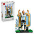 LEGO Lionel Messi soccer collectible features light blue, white, black, gold and green plastic brick construction shaped as the football legend celebrating beside a large number 10 backdrop on a display base.