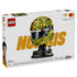 LEGO McLaren Formula 1 helmet retail box showcases yellow, orange and black plastic helmet artwork, Lando Norris branding, a display stand and collectible minifigure on premium packaging.
