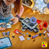 LEGO Olivia Rodrigo Secret Storage in black, gray, lavender and red bricks is spread across a wood table as a builder assembles the music case with digital instructions.