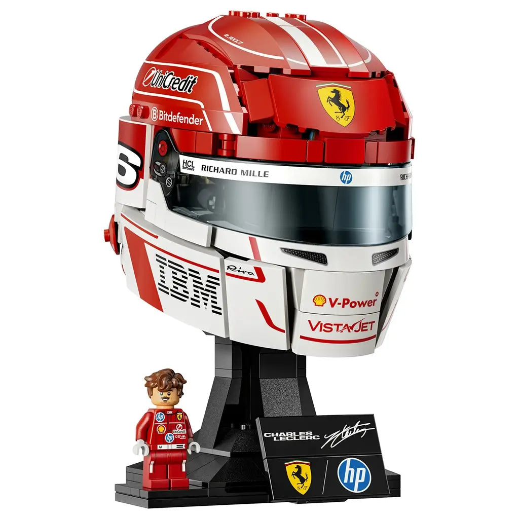 LEGO Ferrari Charles Leclerc helmet model features red, white and black glossy plastic brick construction shaped as a Formula 1 racing helmet with sponsor graphics, displayed on a black stand with minifigure.