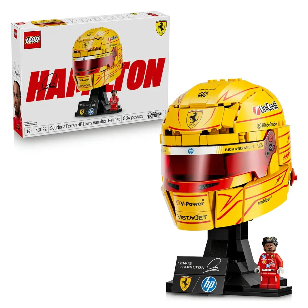 LEGO Ferrari Formula 1 helmet collectible features metallic yellow and red plastic panels with detailed sponsor graphics, a reflective visor, display stand and Lewis Hamilton Ferrari minifigure in a studio setting.