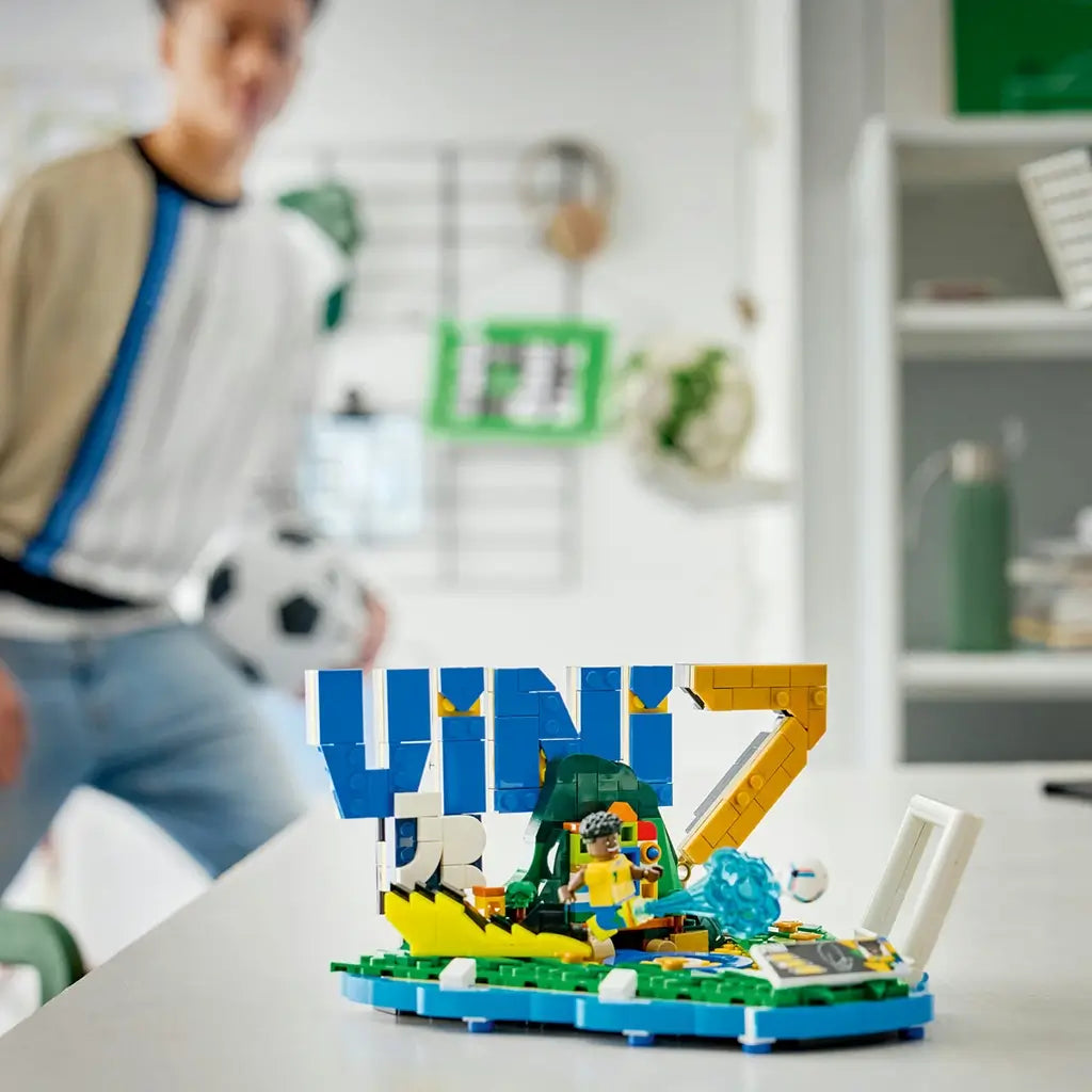 LEGO Editions Vini Jr. Soccer Highlights model features bright blue, yellow, green and white plastic components, football-themed details and a player minifigure displayed in a modern indoor setting with sports decor.