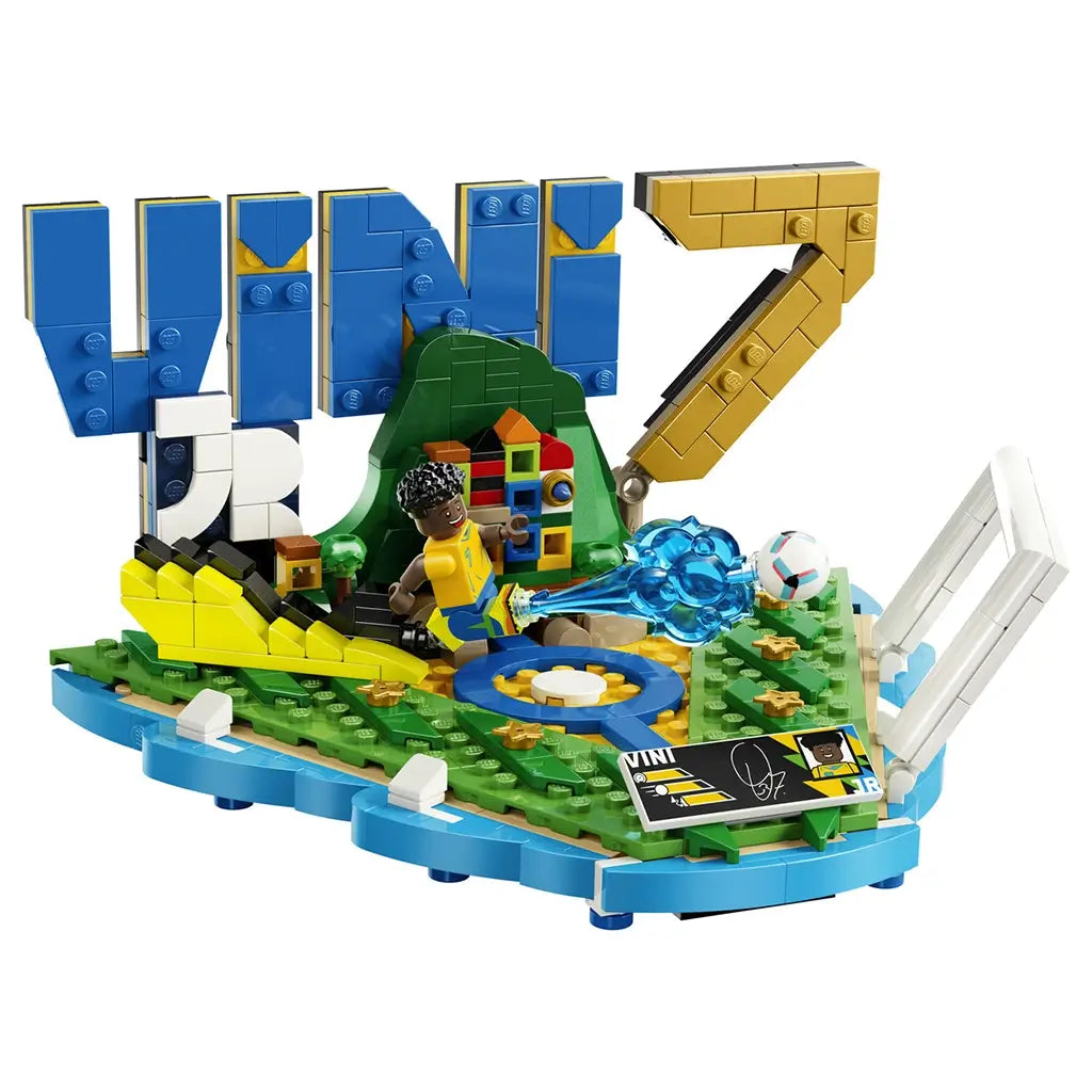 LEGO Editions Vini Jr. Soccer Highlights collectible features blue, yellow, green and white plastic lettering, football goal elements, action-effect details and a player minifigure on a clean studio background.