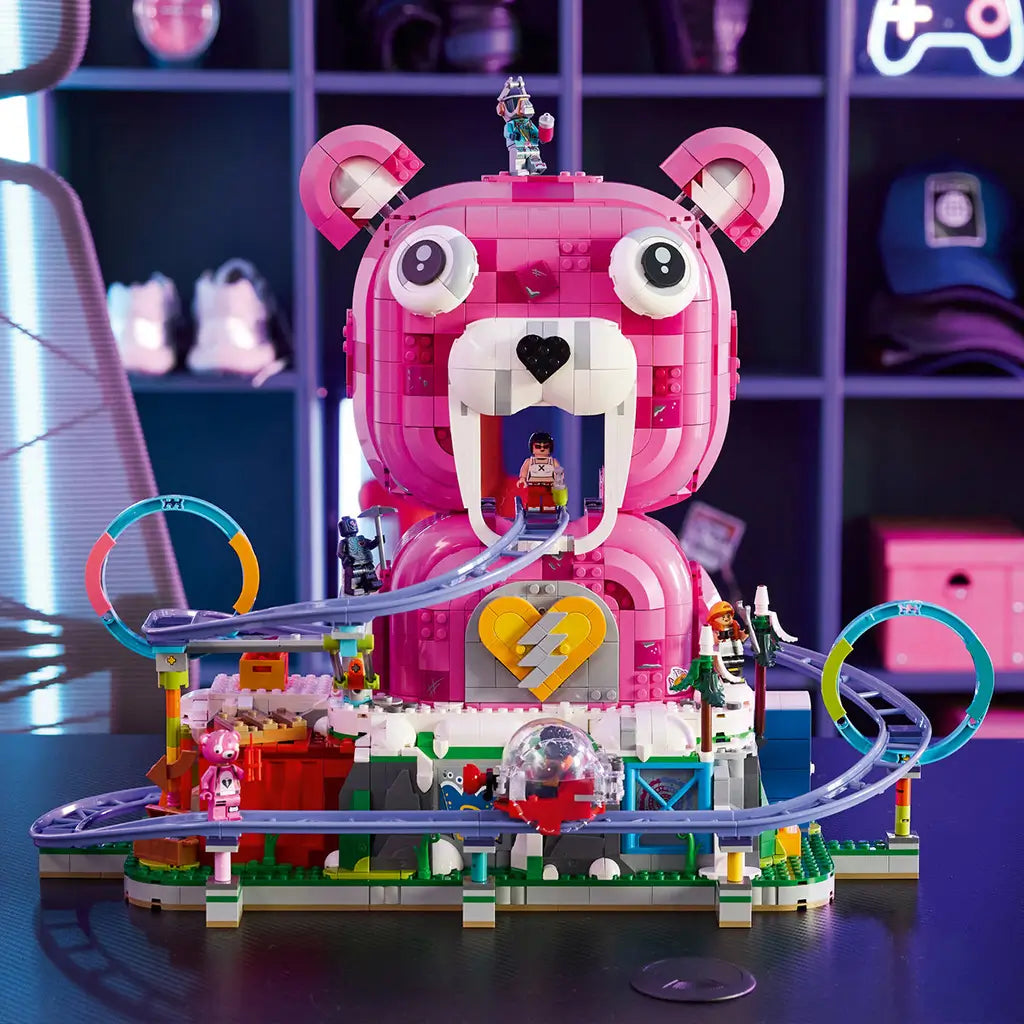 LEGO Fortnite Rave Cave in pink, white and purple plastic bricks, featuring a bear-shaped venue, looping rail track, heart emblem and minifigures in a neon gaming room.