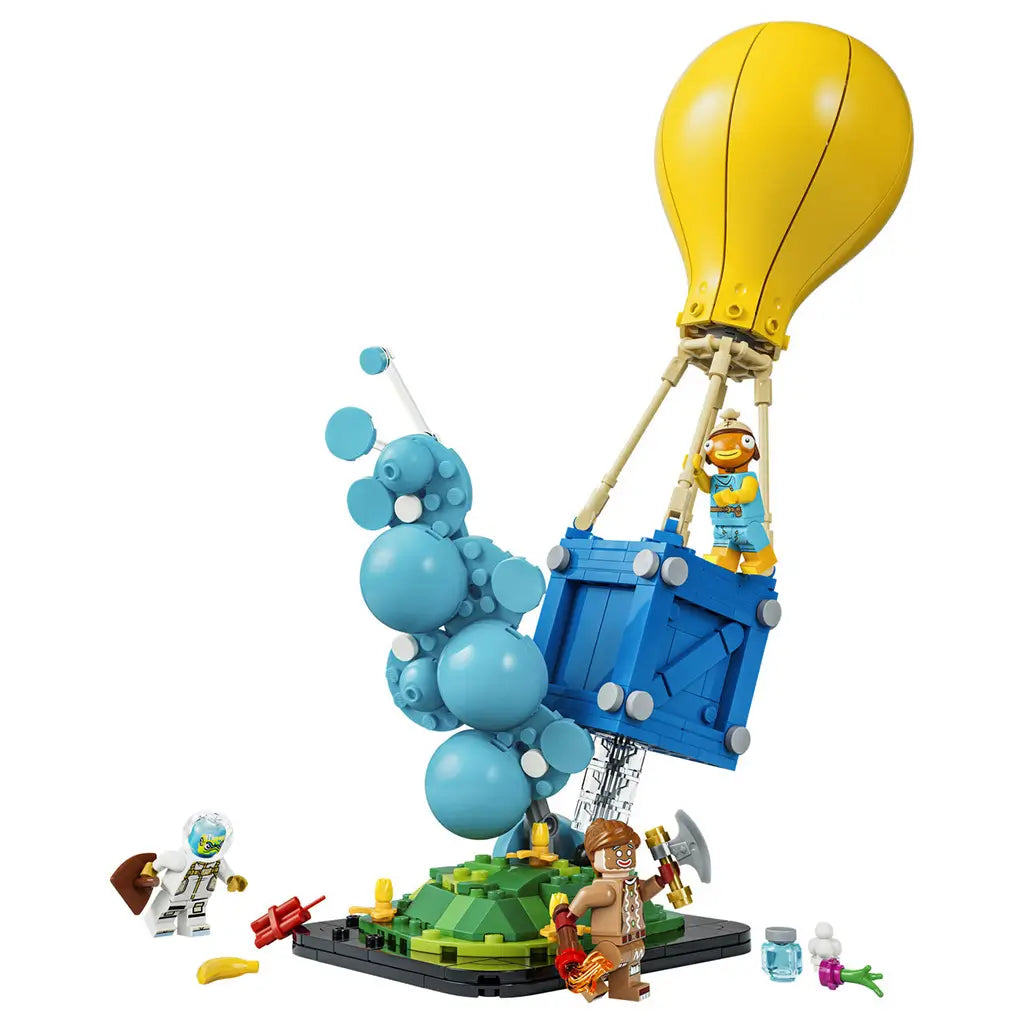 LEGO Fortnite Supply Drop set in yellow, blue and turquoise plastic bricks, featuring a balloon crate, bubble effect, green terrain base, three figures and small accessories.