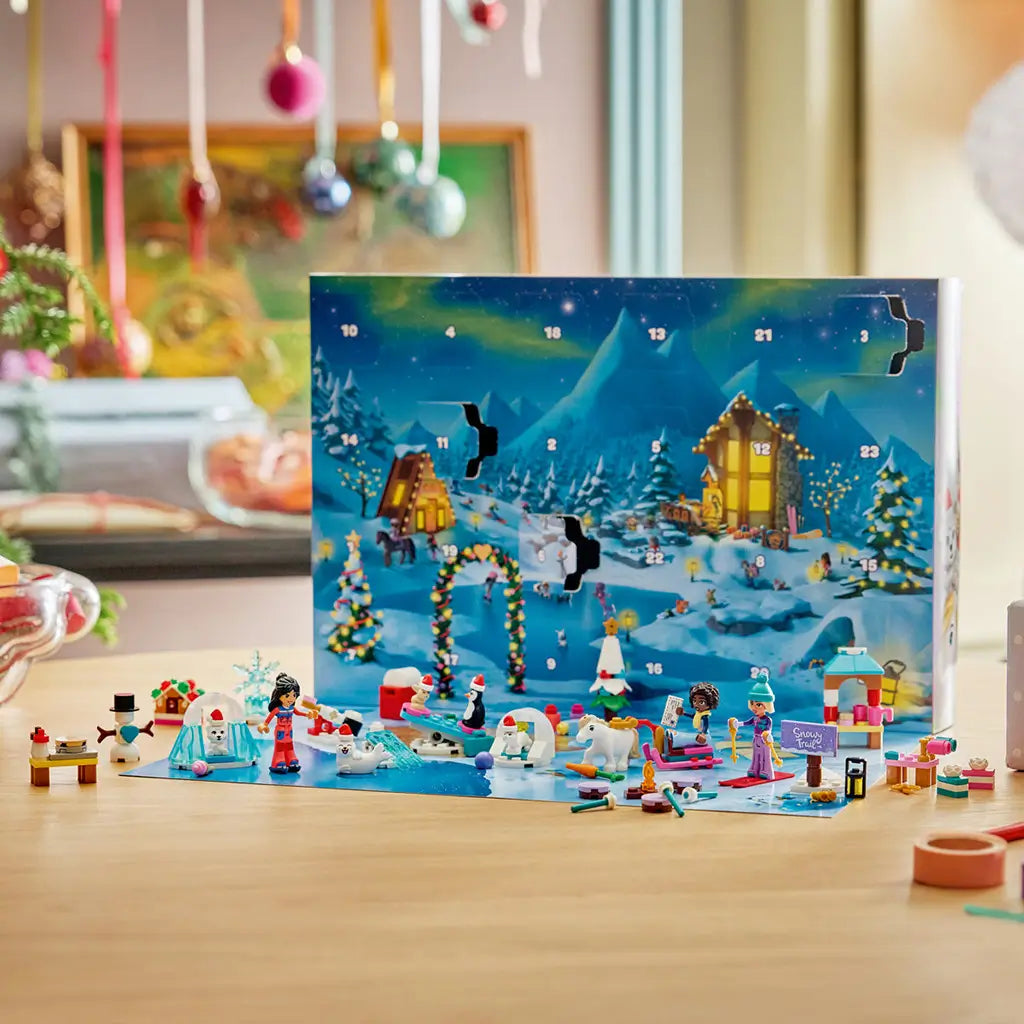 LEGO Friends Advent Calendar 2026 displays colorful plastic mini-dolls, animals, snowman, ski gear and festive builds across a snowy playmat before the opened calendar.