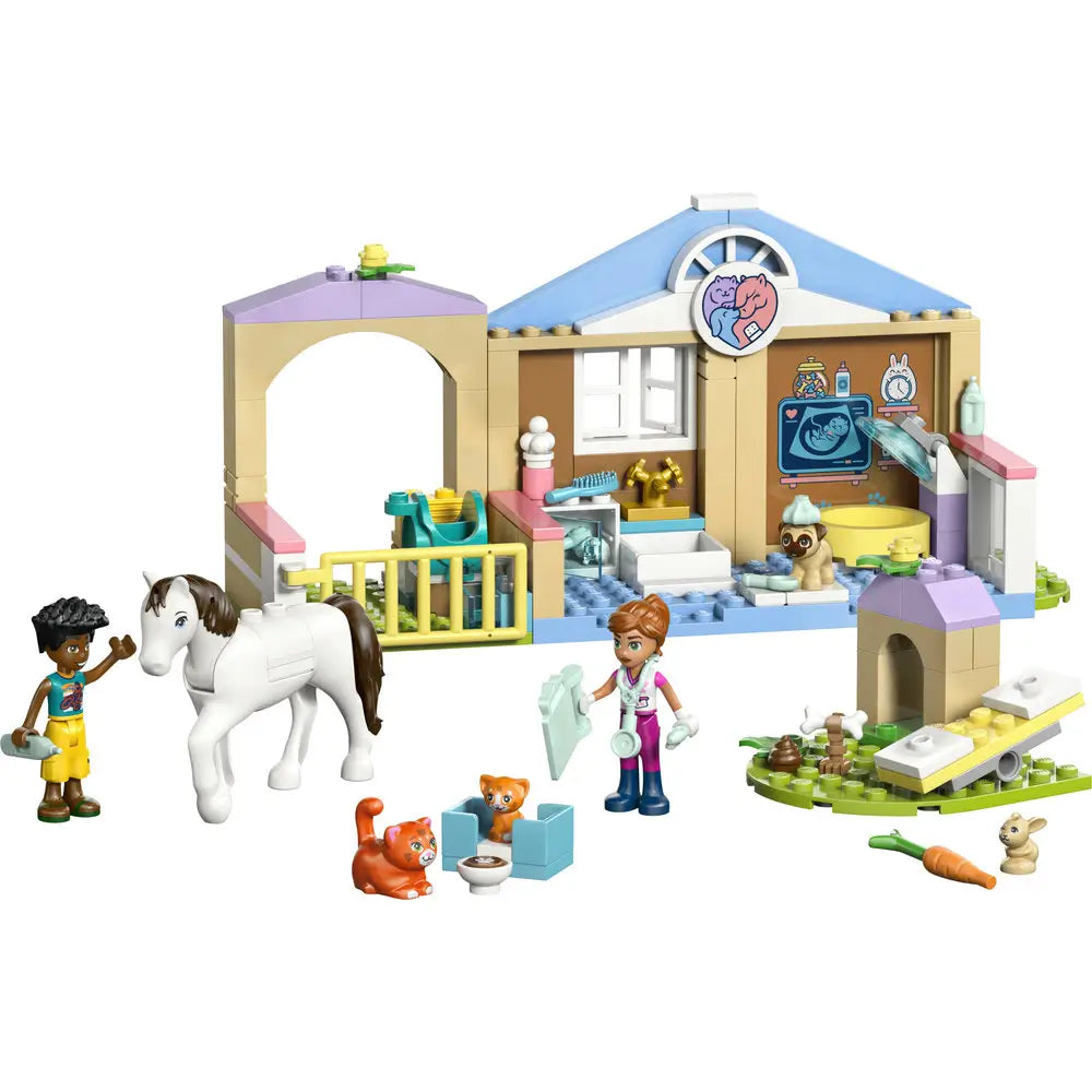 LEGO Friends animal vet clinic playset built in tan, light blue, and pastel plastic bricks, single-story clinic with archway, exam room, fenced yard, and small animals, designed for caring role-play on a clean white background.