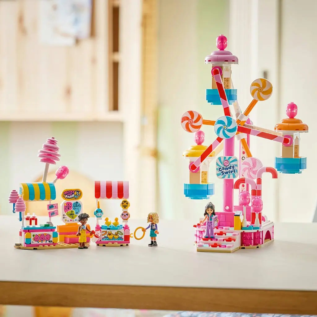 LEGO Friends Candy & Cupcake Ferris Wheel 42700 in pink, blue, and white plastic features candy gondolas, two colorful snack stands, and three mini-dolls on a bright tabletop.