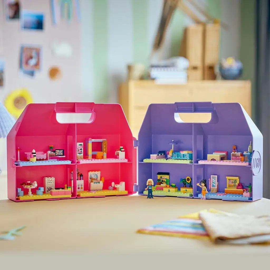 LEGO Friends dollhouse suitcase in bright pink and purple plastic opens into colorful furnished rooms with two mini-dolls, displayed on a table at home.