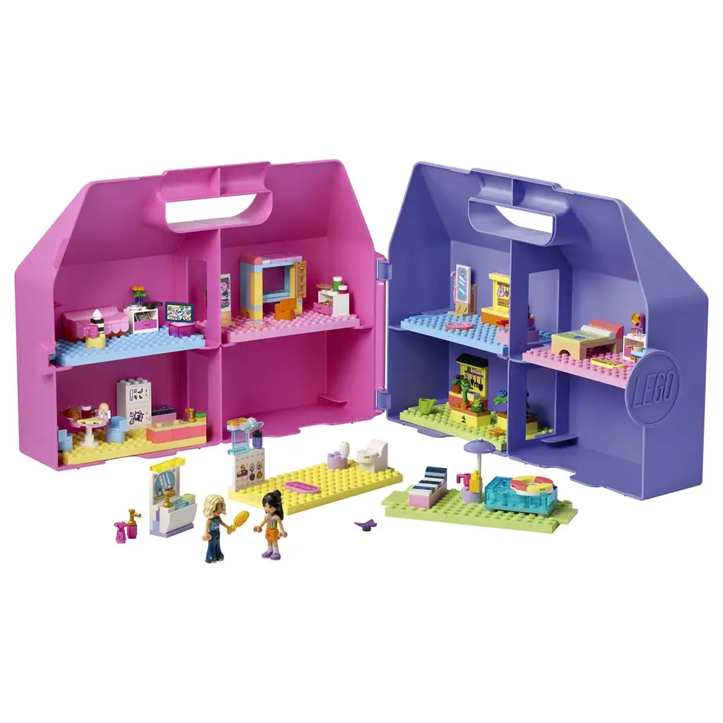 LEGO Friends Creative Dollhouse Suitcase opens as a pink and purple plastic playset with colorful furnished rooms, two mini-dolls, and modular accessories.