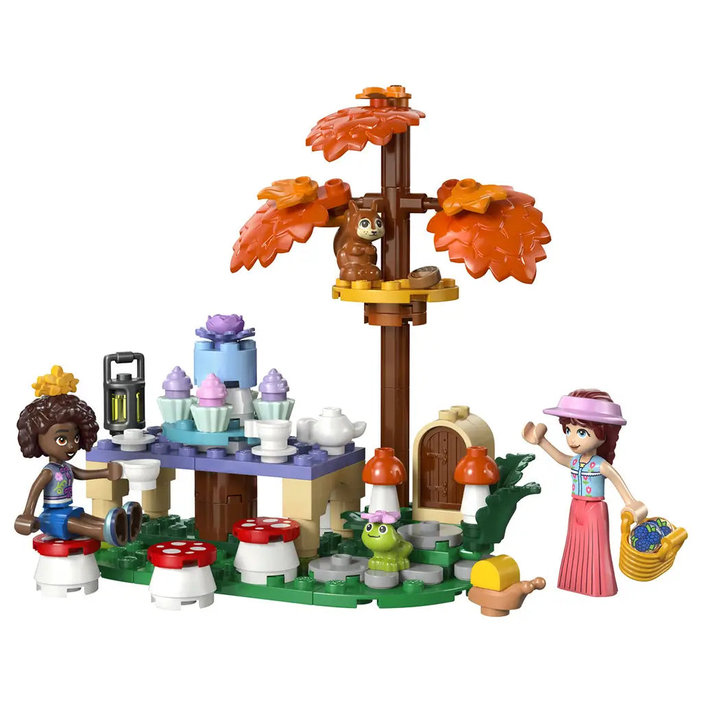 LEGO Friends Forest Tea Party 42690 in green, brown and orange plastic, with two mini-dolls, squirrel, frog, tea table, mushroom seats and autumn tree on white.