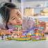 LEGO Friends Fun Water Park Day set in pink, aqua and purple plastic, with a child placing a pet figure near the slide, pool, splash tower and two mini-dolls.