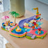LEGO Friends Fun Water Park Day 42676 in pink, aqua and purple plastic, with pool, slide, splash features, palm tree, two mini-dolls and pet figures on a table.