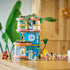LEGO Friends Heartlake City Friends Club House displayed model shows tall blue and pink plastic building with rounded floors, slide, greenery, mini dolls, bicycle, and café accessories arranged in a bright indoor setting.