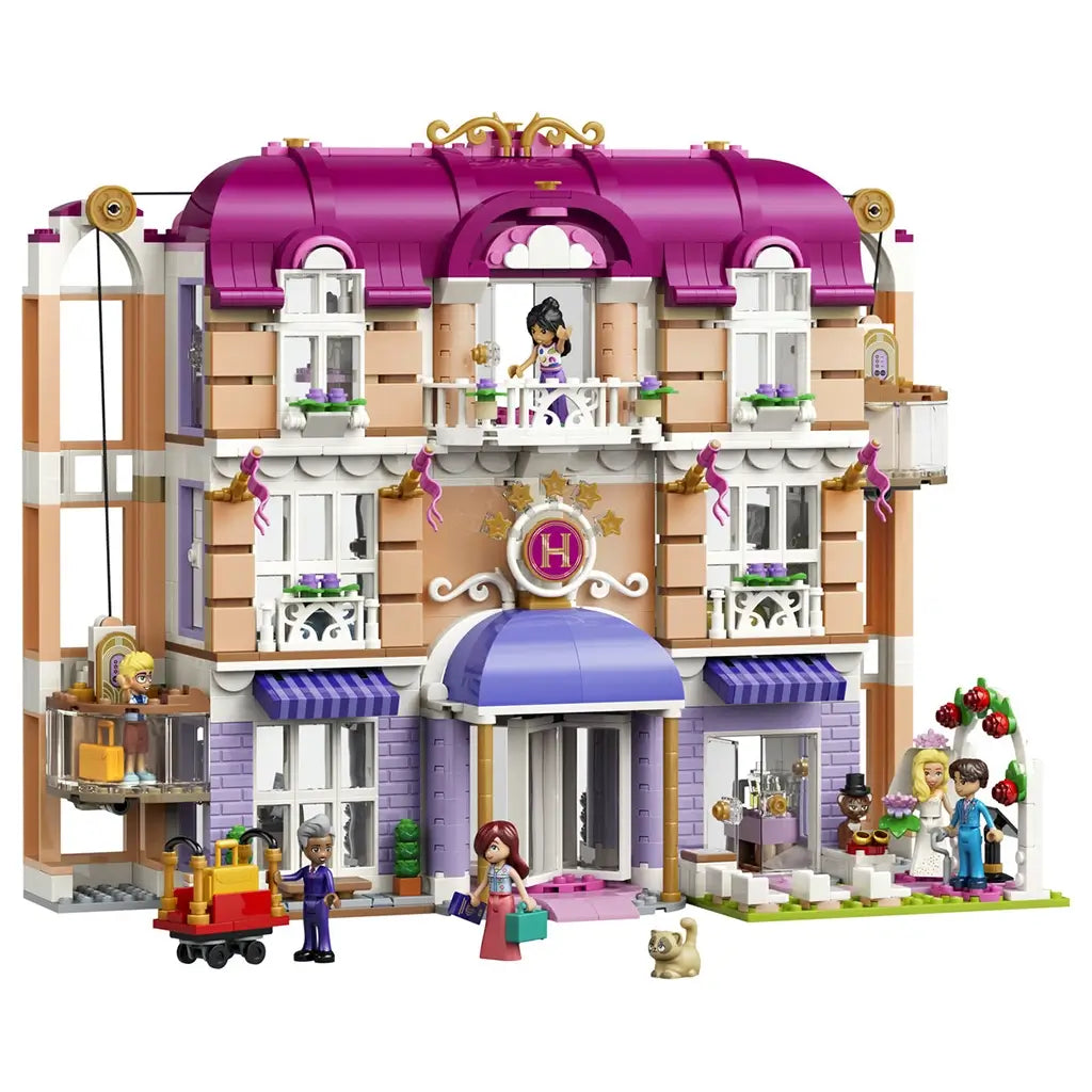 LEGO Friends Heartlake City Grand Hotel set features a pink, white and lavender three-story facade with arched entry, balconies, working elevator, figures, luggage cart and wedding scene.