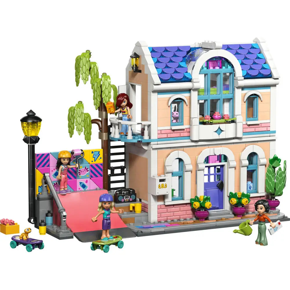 LEGO Friends house playset showing pastel peach and pink plastic bricks forming a two story family home with blue roof, balcony, ramp, plants, and minifigures arranged for imaginative neighborhood play.
