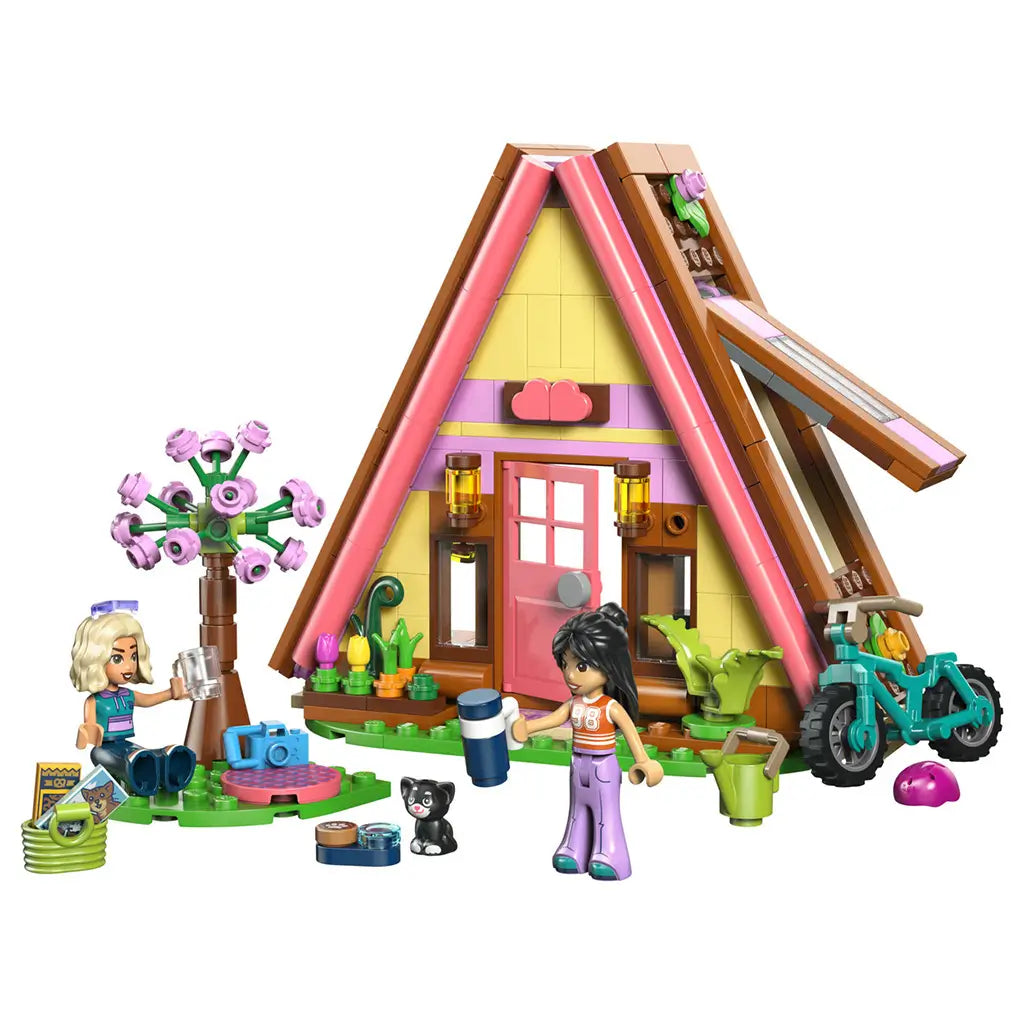 LEGO Friends Nature Glamping Cabin 42682 in pink, yellow and brown plastic, with A-frame cabin, two mini-dolls, black cat, teal bike and camping accessories.