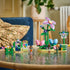 LEGO Friends Spinning Flower & Fairy Teacup Ride display features pink and blue flower seats, a tall purple flower, three mini-dolls and park signs on a reflective table.